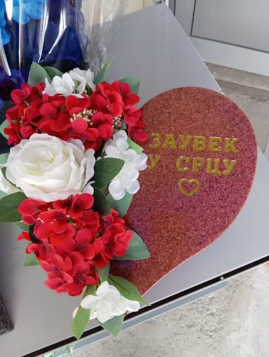 Srce sa natpisom „Заувек у срцу“ i crveno-belim cvećem